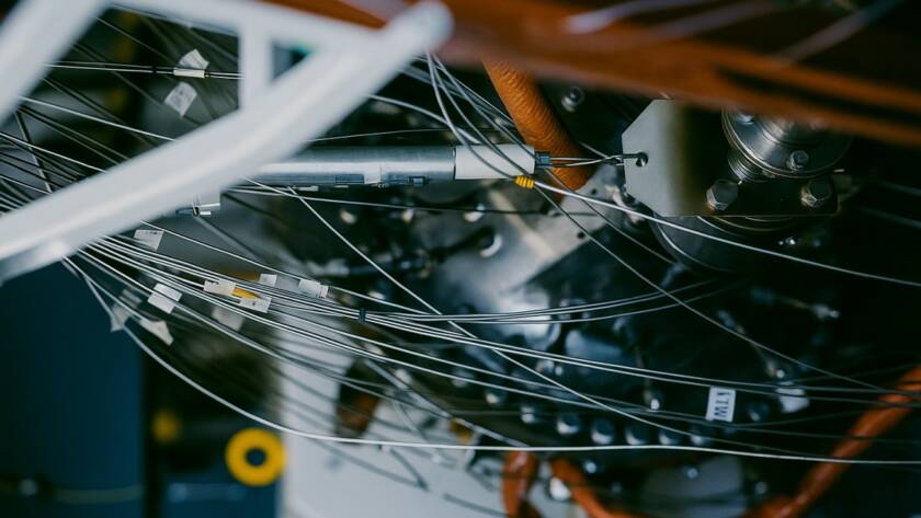 Zbliżenie na zaawansowany reaktor przemysłowy z siecią przewodów i metalowych elementów w zamkniętej instalacji technologicznej.